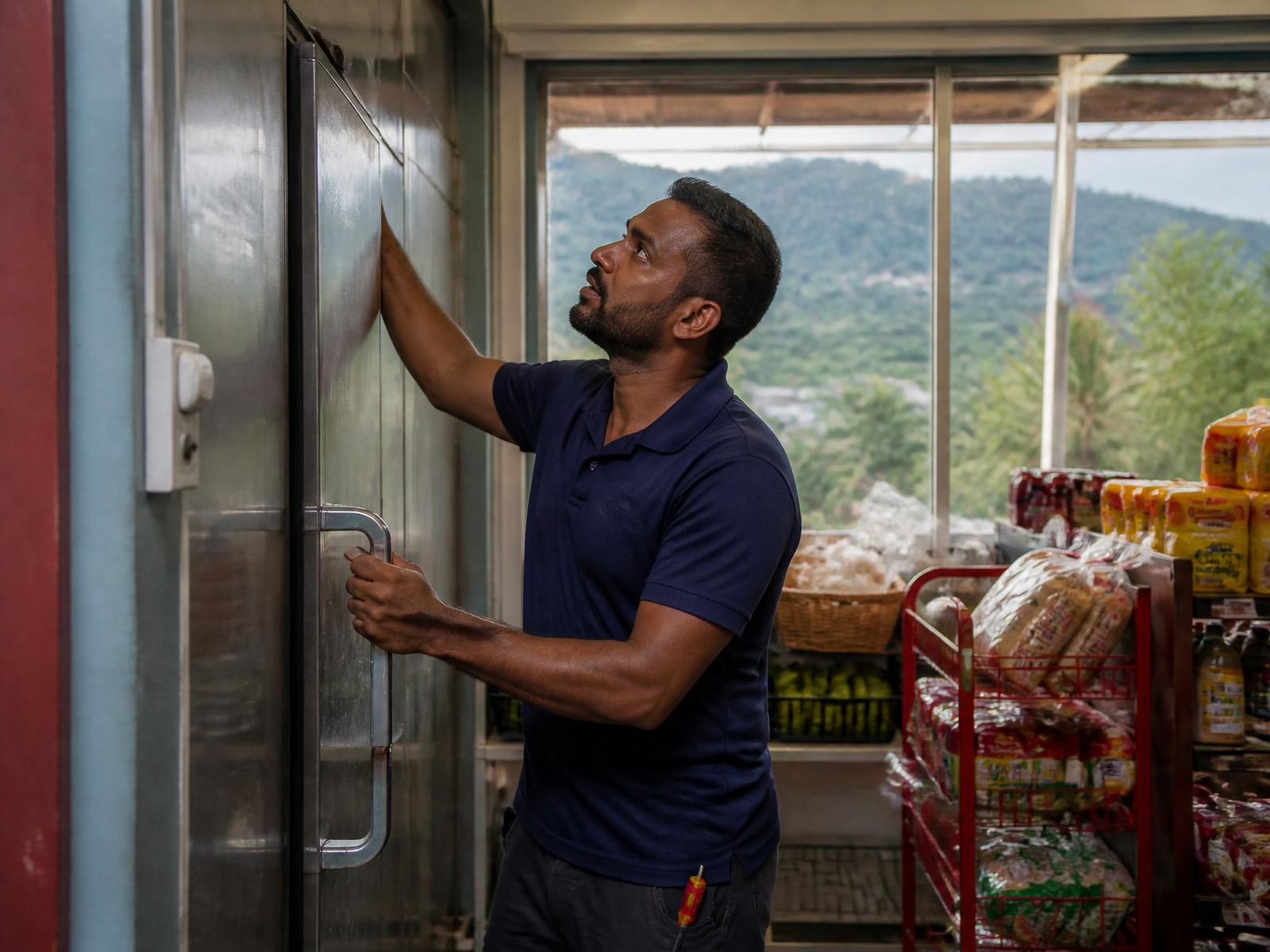 Rondotech technician servicing a walk-in refrigeration unit in a Trinidad grocery
